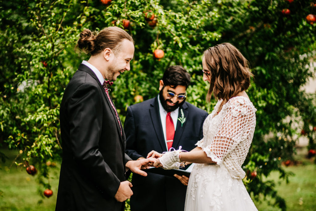 a joyful bridal couple exchanging rings during an intimate wedding ceremony