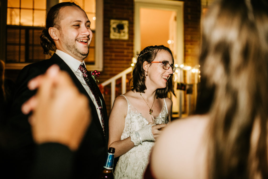 bridal couple talking with their guests while smiling and laughing