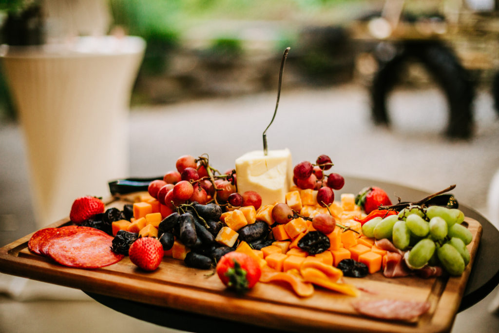 a charcuterie board at an intimate wedding reception with cheese, fruits and meats